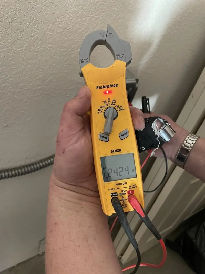 Voltage testing with clamp meter during Recessed Lighting Installation in Eagar